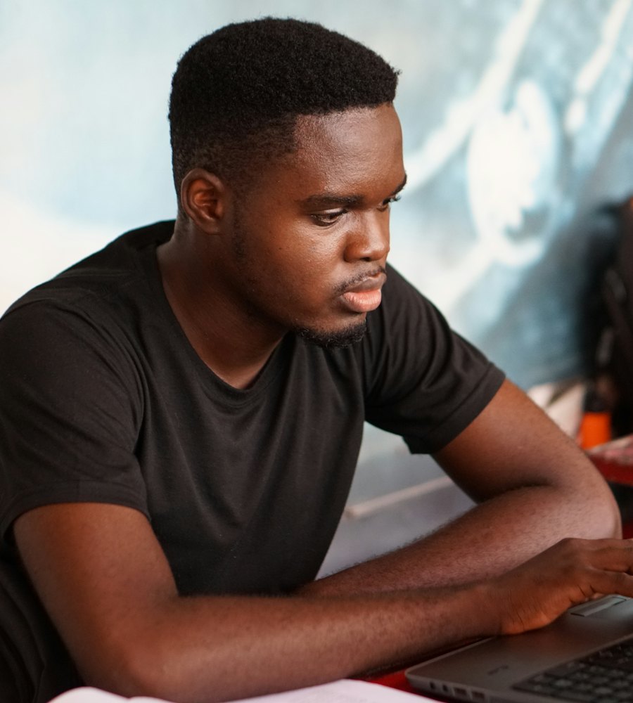 A young Ghanaian professional working on a laptop